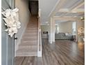Inviting foyer with staircase, beautiful hardwood floors, and views into the spacious living room area at 1052 Bodega Loop, Locust Grove, GA 30248