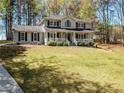 Well-maintained two-story house with a covered front porch and lush green lawn at 3227 Heritage Way, Buford, GA 30519