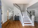 Elegant foyer with hardwood floors, a staircase with black and white accents, and an open view to the living areas at 710 Greystone Ne Park, Atlanta, GA 30306