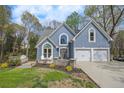 Charming home featuring a well-manicured lawn, two-car garage, and attractive curb appeal at 1007 Springharbor Walk, Woodstock, GA 30188