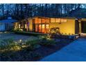 Inviting home exterior at night with warm lighting, mature landscaping, and a security system sign at 1428 Brook Valley Ne Ln, Atlanta, GA 30324