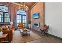 Bright living room with brick accent wall, fireplace, modern lighting, and comfortable leather furniture at 3235 Roswell Ne Rd # 801, Atlanta, GA 30305