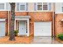 Welcoming front entrance of the townhome featuring a one-car garage and well-manicured yard at 3987 Howell Park Rd, Duluth, GA 30096