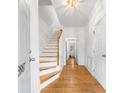 Bright foyer with hardwood floors, staircase, and white trim, creating a welcoming entrance at 3987 Howell Park Rd, Duluth, GA 30096