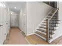 Bright hallway with white trim, interior doors, and a staircase with decorative iron railings at 2990 Fareed St, Douglasville, GA 30135