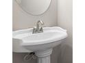 A pedestal sink in a powder room is accented by a circular mirror and neutral wall color at 2990 Fareed St, Douglasville, GA 30135