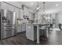 Modern kitchen features gray cabinets, stainless steel appliances, large island, and hardwood floors at 4651 Eddibunn Se Dr, Smyrna, GA 30080
