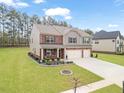 Charming two-story home with a landscaped yard and two-car garage and mixed brick and siding facade at 8033 Louis Dr, Locust Grove, GA 30248