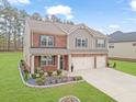 Charming two-story home with a landscaped yard and two-car garage and mixed brick and siding facade at 8033 Louis Dr, Locust Grove, GA 30248
