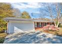 Attached two-car garage with a long driveway and manicured landscaping at the front of the house at 831 Sinyard Rd, Lithia Springs, GA 30122