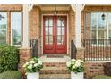 Elegant front entrance with brick columns, double doors, and potted white flowers adding charm at 260 Millstone Pkwy, Woodstock, GA 30188
