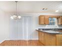 An eat-in kitchen features wood floors, paneled cabinets, and a modern lighting fixture at 2960 Fields Dr, Lithonia, GA 30038