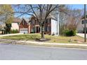 Brick home exterior featuring a manicured lawn, mature tree, and two-car garage at 3220 Warren Creek Dr, Powder Springs, GA 30127