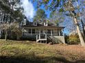 Charming home with a cozy front porch, dormer windows, and a well-maintained yard surrounded by lush trees at 695 Pine Shadows Dr, Dallas, GA 30157