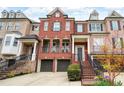 Charming townhome boasts brick facade, a two-car garage, and inviting entry with wrought iron details and manicured landscaping at 1423 Montclair Se Ct # 12, Smyrna, GA 30080