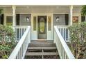 Close-up of front porch with white railings, stylish outdoor lighting, and decorative door with leaded glass at 3320 Woodsfield Ne Dr, Marietta, GA 30062