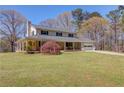 Charming two-story home featuring a welcoming front porch, attached garage, and beautiful yard at 692 W Union Grove Cir, Auburn, GA 30011