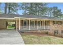 Quaint brick home with large covered parking area and covered front porch at 4089 Menlo Dr, Tucker, GA 30084