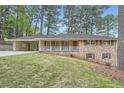 Charming brick home with shutters, manicured lawn and covered parking at 4089 Menlo Dr, Tucker, GA 30084
