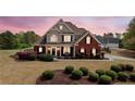 Twilight exterior shot of a two-story, brick home with manicured lawn and shrubs at 179 Country Club Dr, Hiram, GA 30141