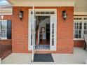 Inviting front entry with double glass doors, brick exterior, and stylish sconces at 179 Country Club Dr, Hiram, GA 30141