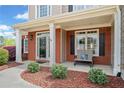 Charming front porch featuring a brick facade, white columns, a bench, and well-maintained landscaping at 179 Country Club Dr, Hiram, GA 30141