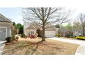Well-manicured home with a two-car garage and a driveway with landscaping at 4520 Vanadium Bnd, Cumming, GA 30040
