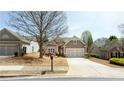A charming house with a two-car garage is complimented by a green lawn at 4520 Vanadium Bnd, Cumming, GA 30040