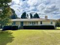 Inviting single-story home with a manicured lawn, classic landscaping, and a welcoming front porch at 5791 Warren Farm Sw Rd, Powder Springs, GA 30127