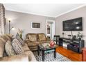 Comfortable living room with hardwood floors, neutral walls, a plush sofa, and a flat screen television at 1257 Lyle Pl, Atlanta, GA 30318