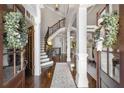 Elegant foyer with hardwood floors, staircase, and decorative wreaths on glass doors at 145 Cuthbert Ln, Acworth, GA 30101