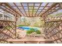 View of the inviting backyard pergola with swing overlooking the glistening blue swimming pool at 2121 Rock Court, Loganville, GA 30052
