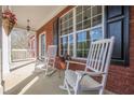 Inviting front porch featuring classic rocking chairs and hanging flower baskets at 2121 Rock Court, Loganville, GA 30052