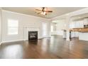 Cozy living room with fireplace, hardwood floors, open to kitchen with breakfast bar and neutral paint at 245 Astoria Way, Mcdonough, GA 30253