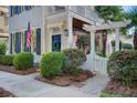 Landscaped walkway leading to the front entrance, showcasing manicured bushes and a charming white gate with pergola at 4124 Hunt St, Covington, GA 30014