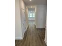 Bright hallway featuring hardwood floors, white walls, and access to various rooms at 89 Mayhaw Pt, Sharpsburg, GA 30277