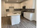 Modern kitchen featuring white cabinets, gray backsplash, stainless steel appliances and island at 89 Mayhaw Pt, Sharpsburg, GA 30277