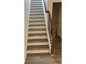 Staircase with light-colored wood steps, white risers, and a dark wood railing at 89 Mayhaw Pt, Sharpsburg, GA 30277