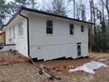 View of home showing basement access, white painted brick and siding and modern lines at 3543 S Cobb S Dr, Smyrna, GA 30080