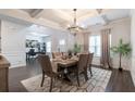 Open dining space with coffered ceilings, a modern chandelier, and an adjacent office provides a versatile layout at 4824 Sultana Sw Way, Atlanta, GA 30331