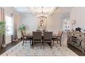 Bright dining area boasts stylish decor, a modern chandelier, and an adjacent kitchen with granite countertops at 4824 Sultana Sw Way, Atlanta, GA 30331