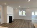 Bright living room with wood floors, fireplace, recessed lights, and sliding glass doors to the porch at 76 Mayhaw Pt, Sharpsburg, GA 30277