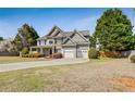 Charming two-story home featuring stone accents, a two-car garage and a lawn at 8450 Sundial Ct, Johns Creek, GA 30024
