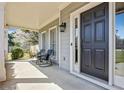 Inviting front porch featuring a dark front door, seating and stylish lighting at 8450 Sundial Ct, Johns Creek, GA 30024