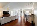 Open-concept living room with hardwood floors flowing into the dining area and kitchen bar at 195 14Th Ne St # Ph206, Atlanta, GA 30309