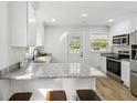 Bright kitchen featuring white cabinets, granite countertops, stainless steel appliances, and a breakfast bar at 2519 Miriam Ln, Decatur, GA 30032