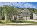 Traditional home boasts manicured lawn, mature trees, and a two-car garage at 349 Pennant Ln, Fairburn, GA 30213