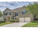 Inviting two-story home featuring lush landscaping, a two-car garage, and a welcoming front entrance at 349 Pennant Ln, Fairburn, GA 30213