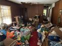 Cluttered living room with wood paneled walls and a window at 5804 S South Gordon Sw Rd, Austell, GA 30168