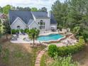 Backyard oasis with a large freeform pool, hot tub, stone waterfall and lounge seating at 3541 Haddon Hall Dr, Buford, GA 30519
